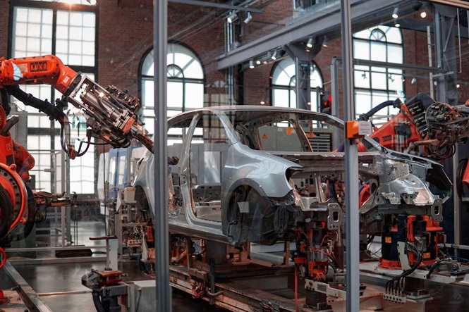 A car factory works on a car body, representing how RED Shield Administration is interested in new automotive technology